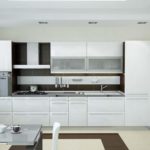 Design liniar al bucătăriei albe în interiorul unui apartament din oraș