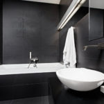Surface de plomberie blanche de salle de bain en intérieur noir