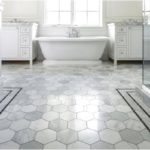 White bathroom with gray and white honeycomb tiles on the floor