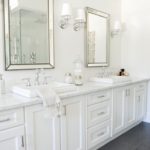 Balta vannas istaba ar pelēkām glancētām flīzēm uz grīdas