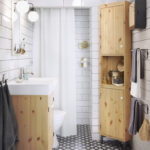 Salle de bain blanche avec murs carrelés et motif géométrique au sol