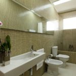 Design of a bathroom in a private house; tiled and white sanitary ware