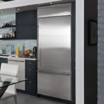 Réfrigérateur gris métallique à l'intérieur de la cuisine en noir et blanc