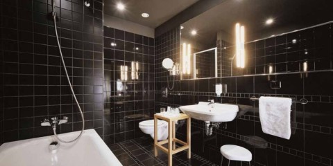 Salle de bain design moderne avec carrelage noir et plomberie blanche