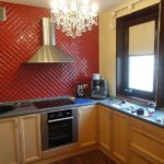 Diagonal laying of red tiles on the kitchen wall