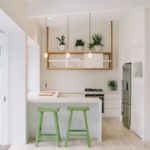 Ghế bar màu xanh lá cây trong nhà bếp màu trắng