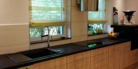 Linear kitchen interior along a wall with two windows