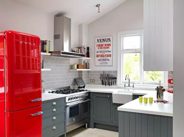 Sarkans ledusskapis privātmājas virtuves interjerā