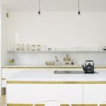 Duvardaki bir raf ile beyaz mutfak