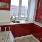 المطبخ في مبنى شاهق باللون الأحمر ومع بالوعة في النافذة