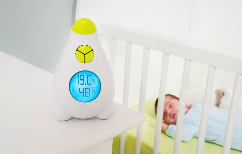 Yeni doğmuş bir bebek beşik yakınındaki termometre
