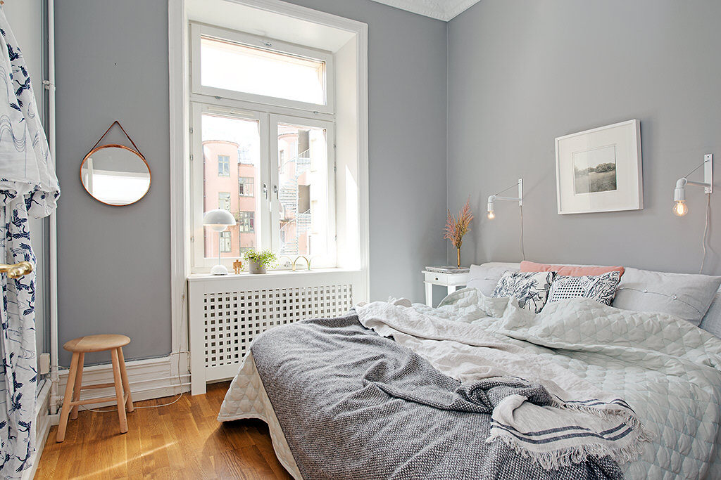 Küçük bir yatak odasında açık gri duvarlar