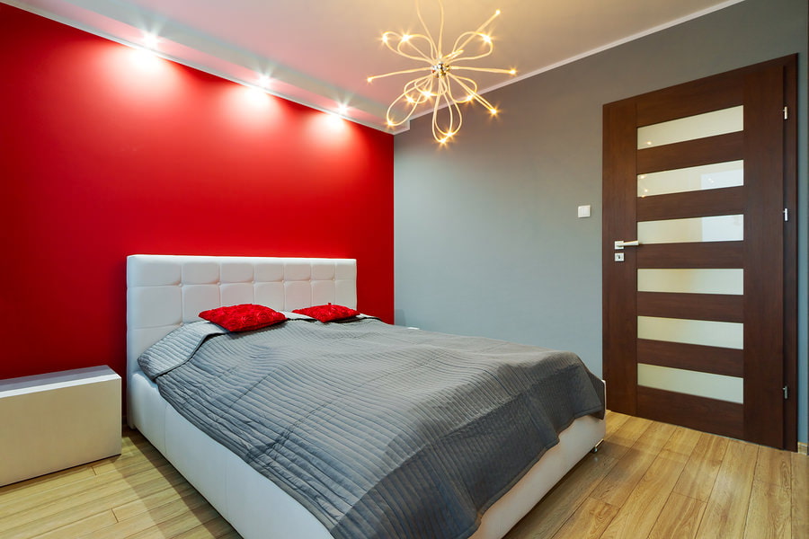 קיר אדום בפנים חדר שינה קטן