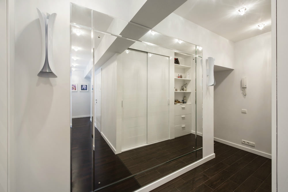 Mirror wall in the narrow corridor of the apartment