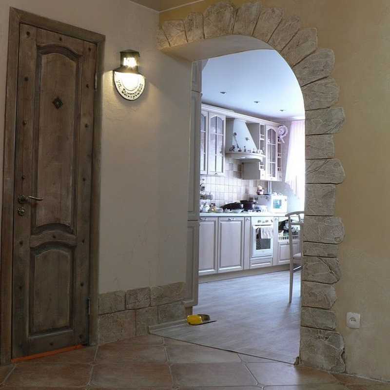 Arche à décor de pierre dans le hall d'entrée d'une maison à panneaux