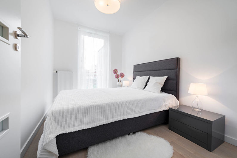 سرير رمادي في غرفة نوم بيضاء مساحتها 10 أمتار مربعة