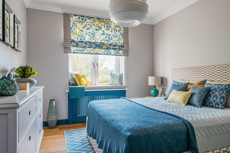 Couvre-lit bleu dans une chambre aux murs gris