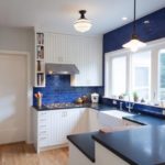 مطبخ أبيض مع منطقة عمل من الطوب الأزرق وكونترتوب أزرق