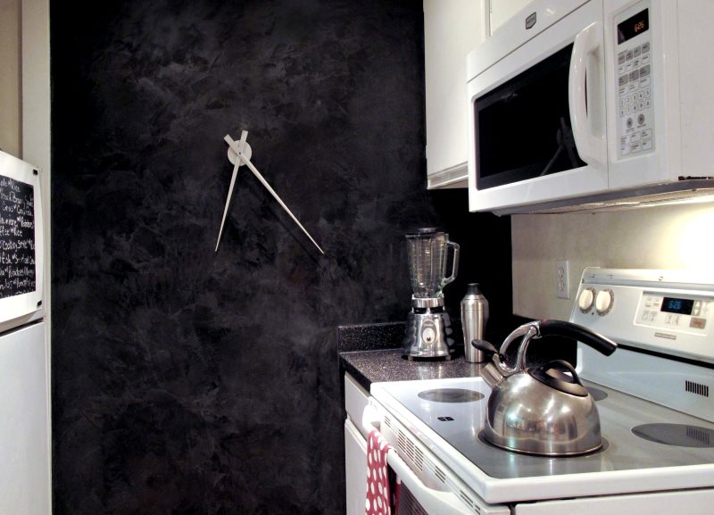 Küçük bir mutfak karanlık duvardaki tasarımcı saat