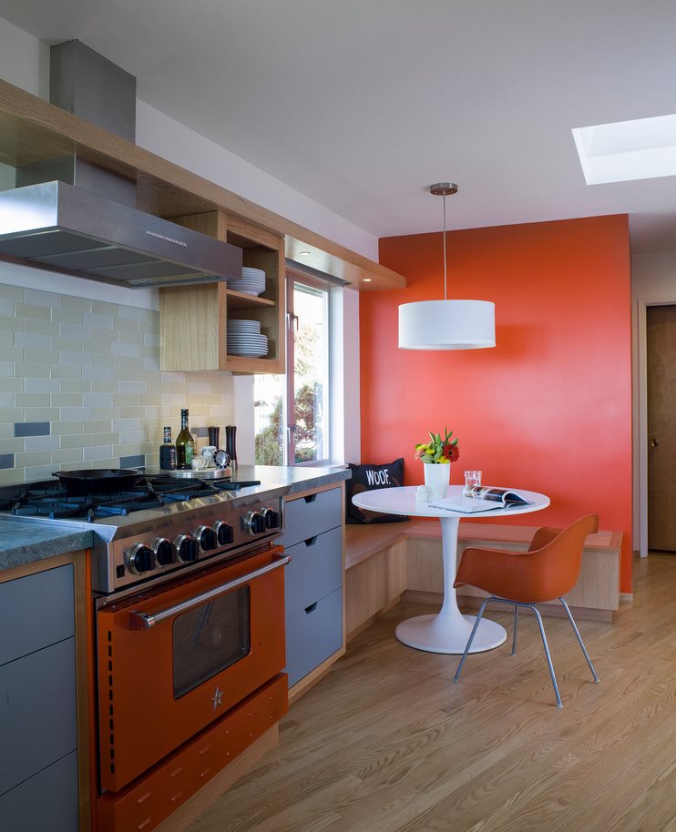 الأرضيات الخشبية في المطبخ مع الجدار البرتقالي