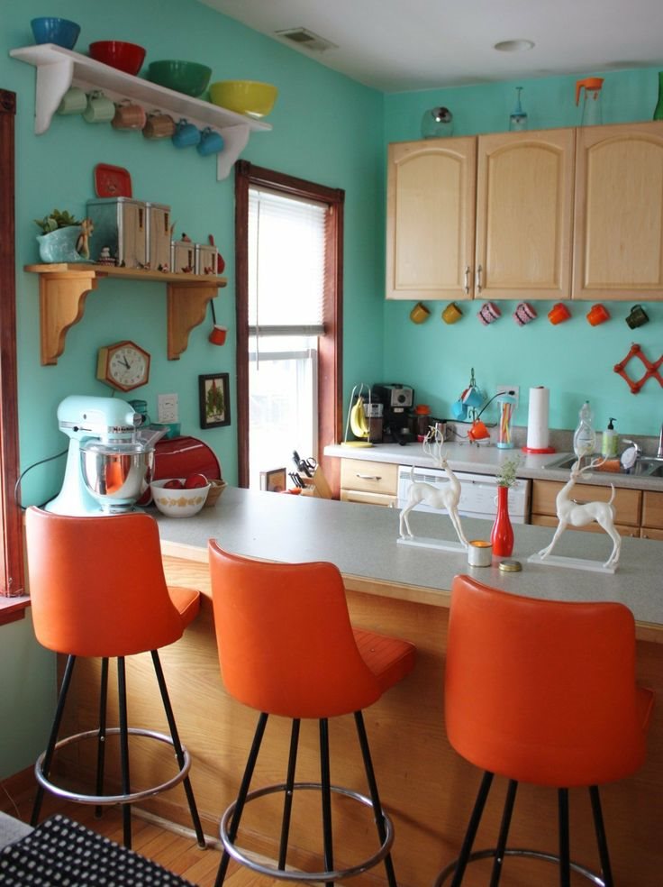 جدران النعناع في المطبخ مع كراسي برتقالية
