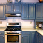 Parlak bir mutfakta koyu mavi klasik mobilya