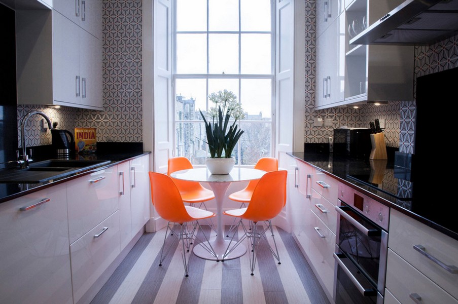 Orangefarbene Stühle in schmaler Parallelküche