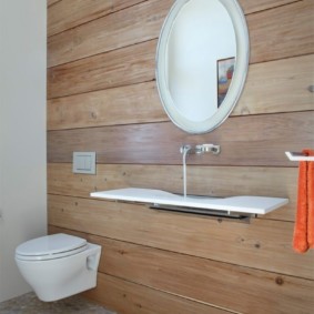 Toilettes suspendues sur un mur de maison en bois