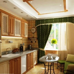 Zielone zasłony z lambrekinem na oknie w kuchni-salonie