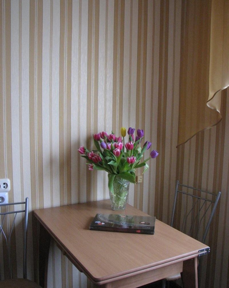 Mesa de comedor junto a la pared con papel pintado a rayas