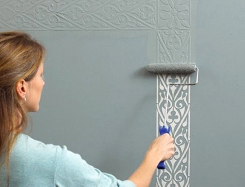 Dessiner une couche de peinture décorative sur un mur à travers un pochoir
