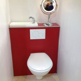 Toilettes blanches sur un mur rouge