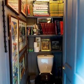Étagères avec des livres dans les toilettes d'une maison de campagne