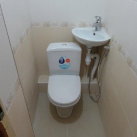 Lavabo d'angle sur le mur derrière les toilettes