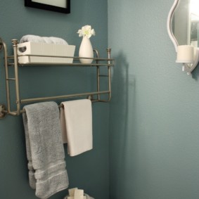 Shelf with a hanger for a towel over a toilet bowl