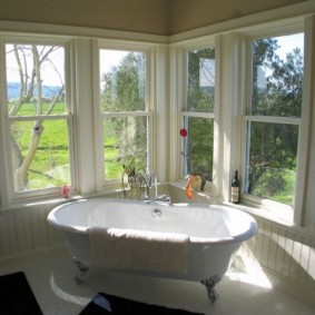 Bathtub in a room with wooden windows