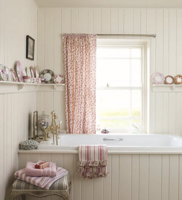 A colorful curtain on the bathroom window in the style of shabby chic
