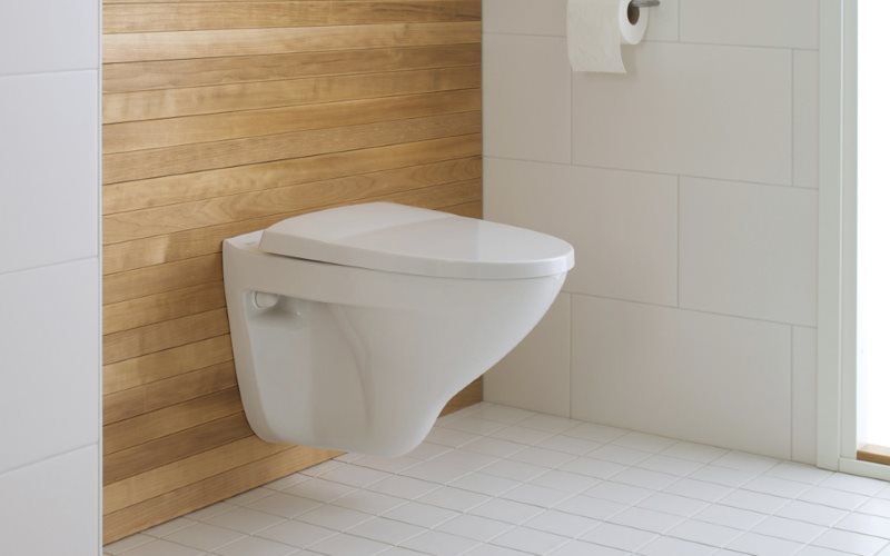 Toilette suspendue blanche sur un mur en bois