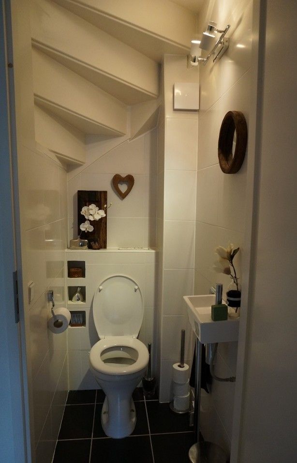Intérieur des toilettes sous un escalier en colimaçon