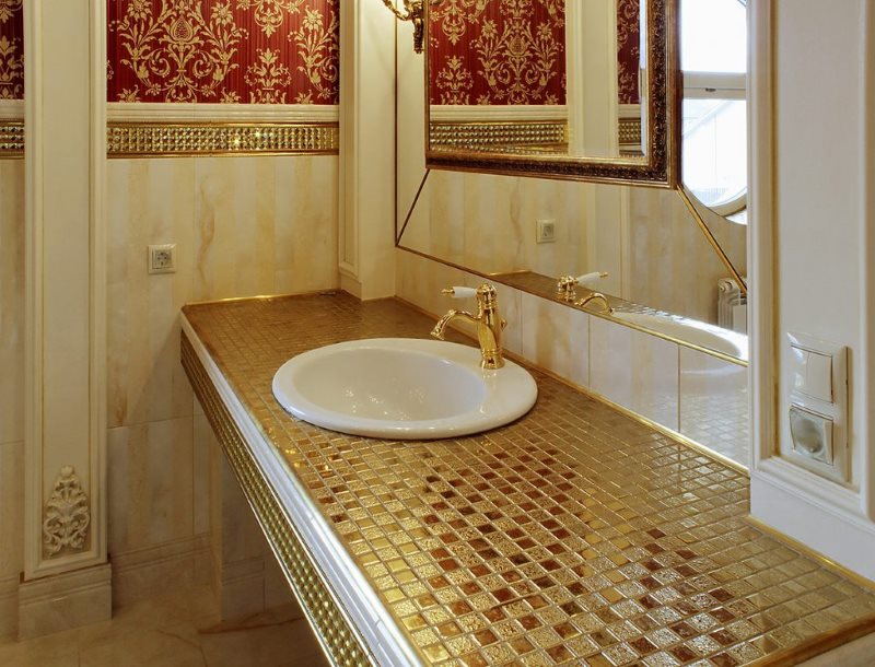 Mosaïque avec une surface dorée sur le comptoir de la salle de bain