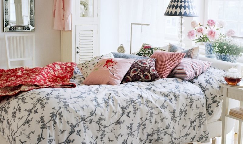 Rustik bir yatak odasında bir yatakta dekoratif yastıklar