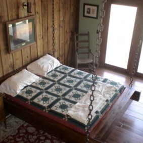 Grand lit sur chaînes dans la chambre d'une maison privée