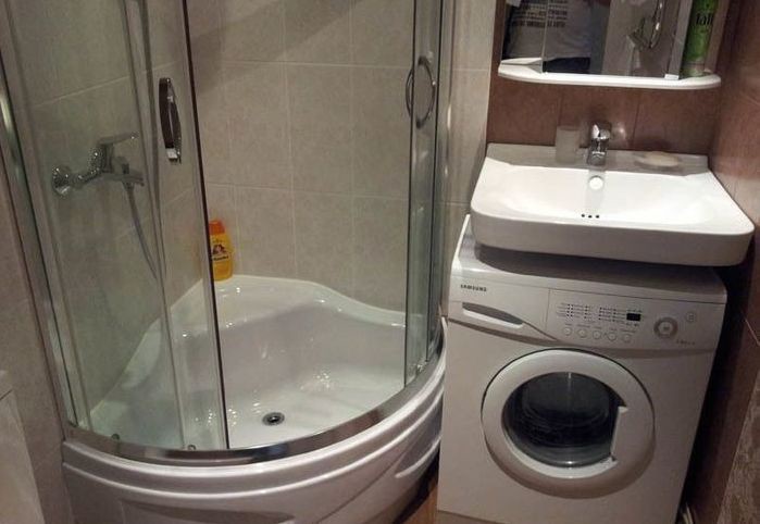 Çamaşır makinesi ile küçük bir banyoda köşe kabin