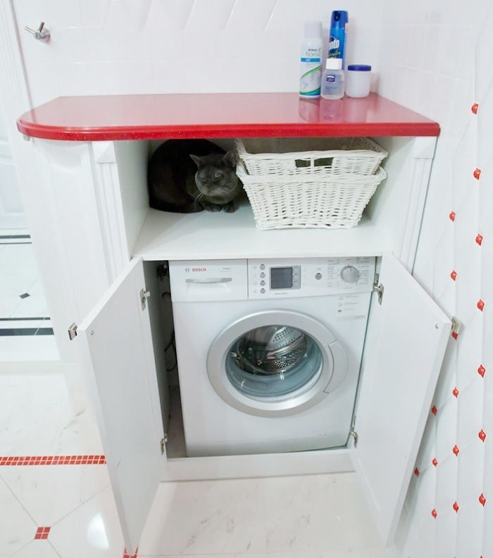 Banyoda çamaşır makinesi üzerinde kırmızı raf