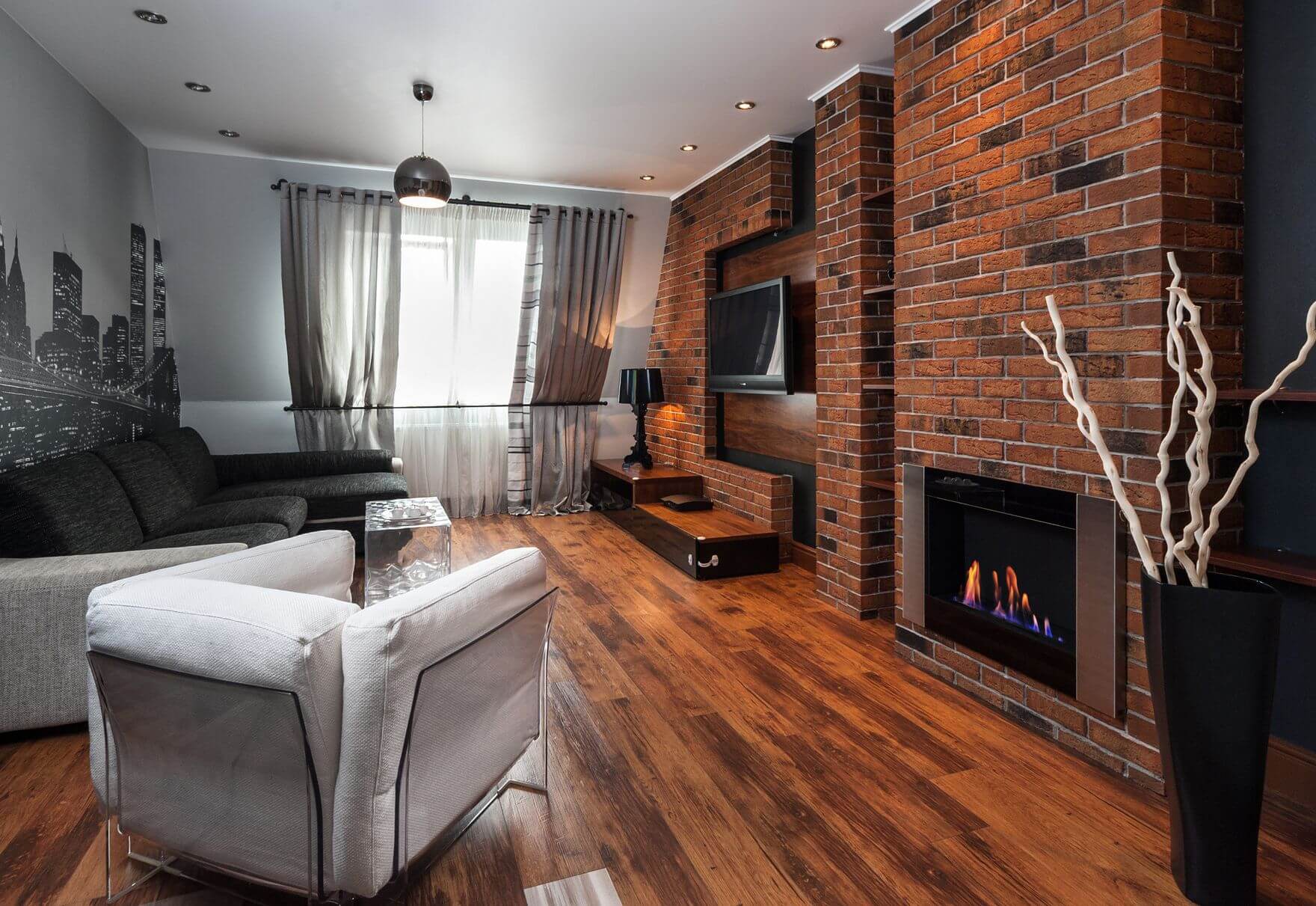 mur de briques avec cheminée et TV dans le salon