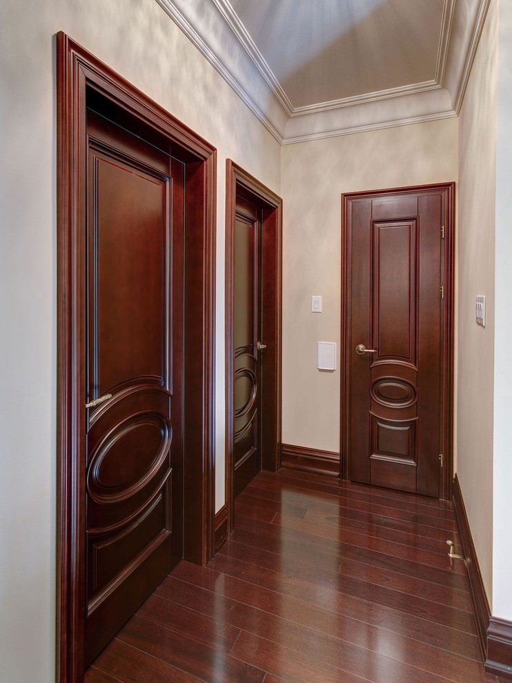 Dark wooden doors in the narrow corridor of the apartment