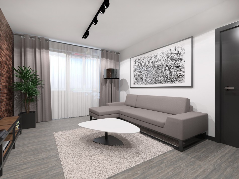Pelēks dīvāns pret baltu sienu studijas tipa dzīvoklī