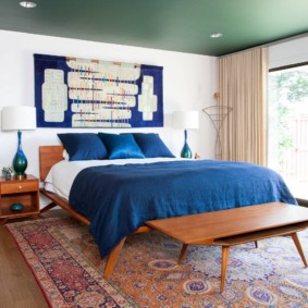Blue bedspread on a wide bed