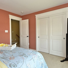 Pembe bir yatak odasında beyaz kapılar
