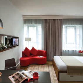 ספה אדומה בסלון עם שני חלונות